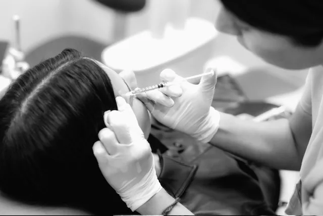 A neuromodulator treatment being administered by a gloved clinician at Ageless Medical Aesthetics in Hollywood, Florida